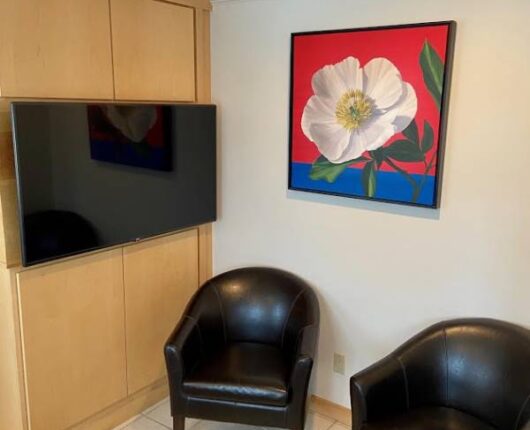 The waiting area with T.V. & Black chairs